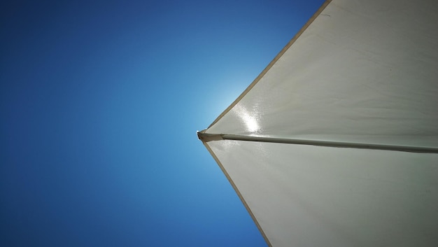 Photo low angle view of parasol against clear blue sky