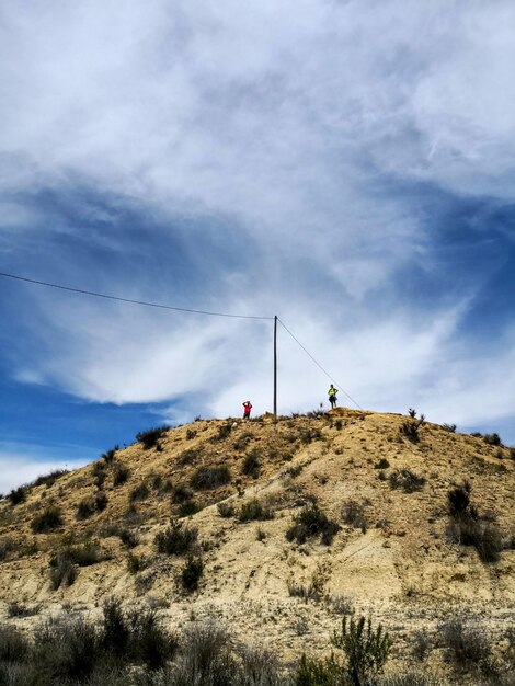 Photo low angle view of people on mountain against sky