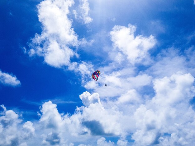 Foto vista a basso angolo di persone in parapendio contro il cielo blu