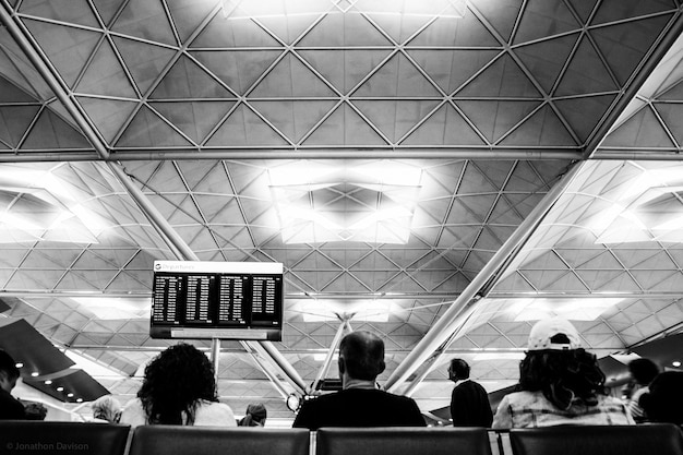 Photo low angle view of people sitting at airport departure area