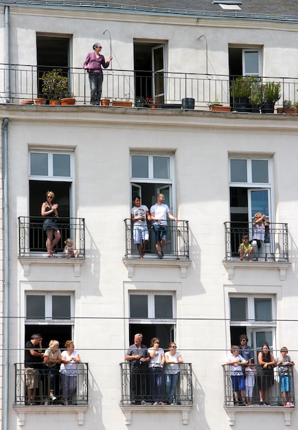 Photo low angle view of people standing in balcony on sunny day