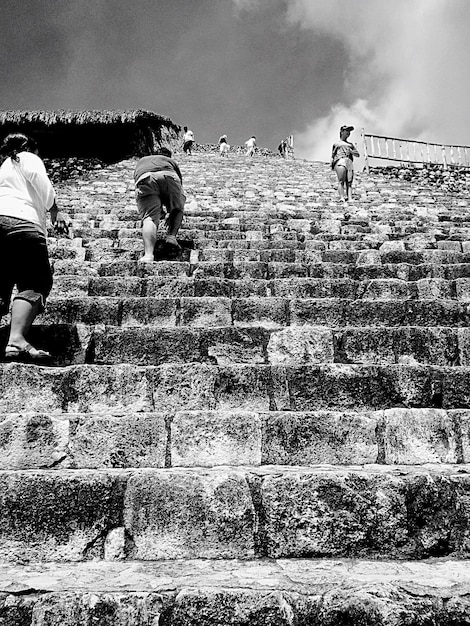 Photo low angle view of people walking on steps against sky
