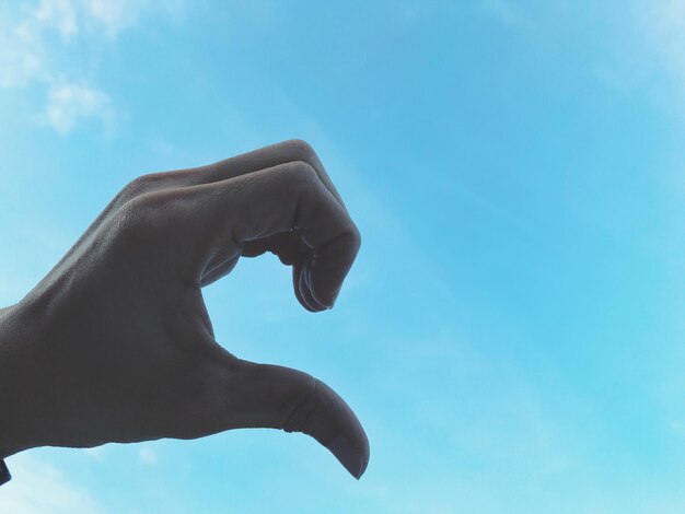 Low angle view of person against blue sky