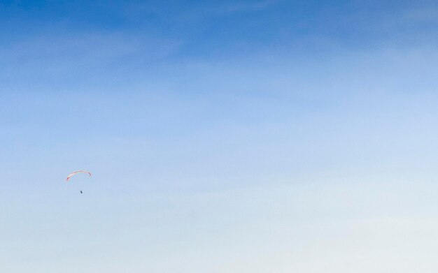 Photo low angle view of person paragliding against blue sky