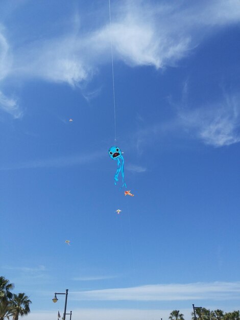 Foto vista a basso angolo di una persona in parapendio contro il cielo blu