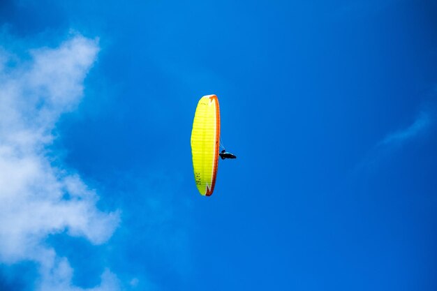Photo low angle view of person paragliding against blue sky