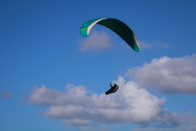 Low angle view of person paragliding against sky