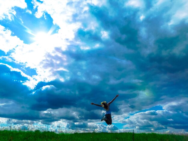 Low angle view of person paragliding against sky