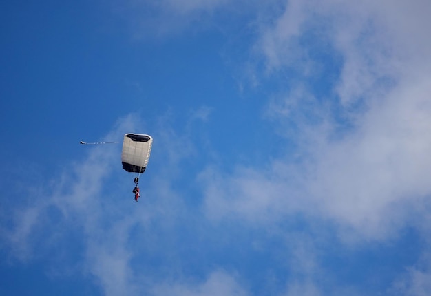 Low angle view of person paragliding against sky