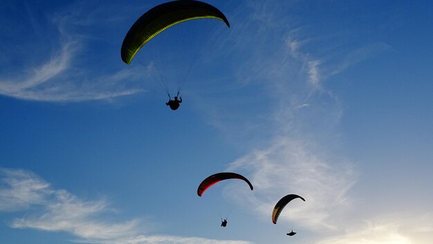 Low angle view of person paragliding against sky