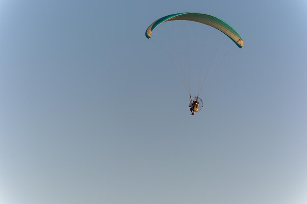 Low angle view of person powered paragliding against clear sky