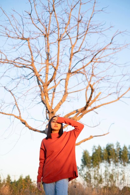 Photo low angle view of person standing by bare tree against sky