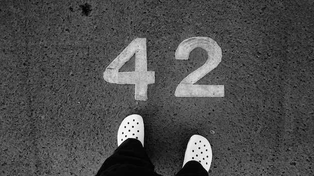 Photo low angle view of person standing in front of number on footpath