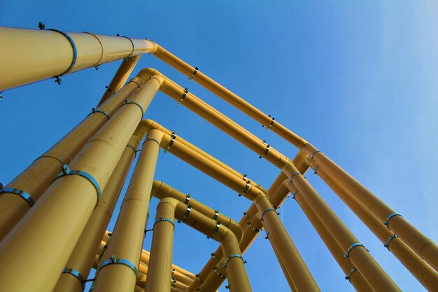 Low angle view of pipeline against clear blue sky