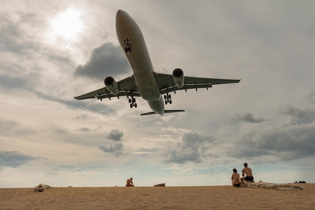 low angle view of plane flying over beach against sky
