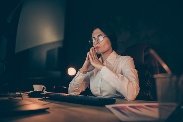 Photo low below angle view portrait of her she nice attractive lovely stylish smart clever experienced lady expert auditor top manager solving difficult task startup at night dark work place station indoors