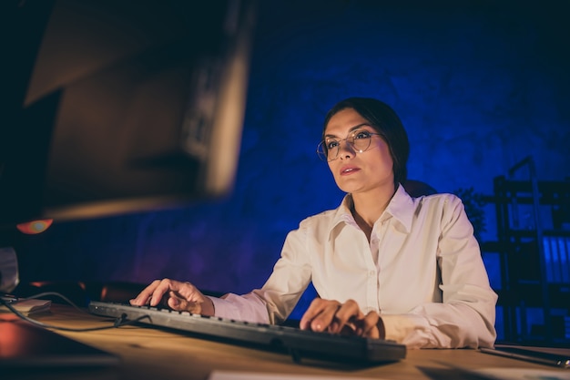 Low below angle view portrait of nice attractive smart clever lonely lady top ceo boss chief creating design project launch meeting deadline after everyone left night dark work place station