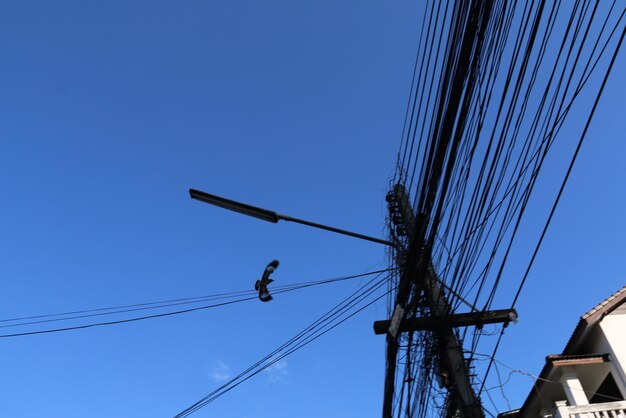 Low angle view of power lines against blue sky