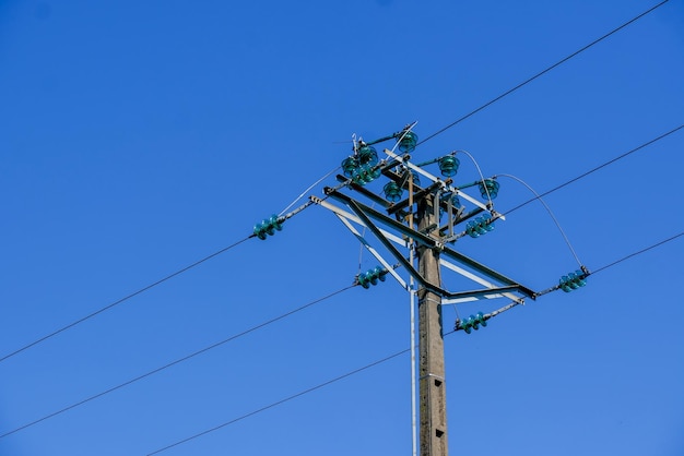 Low angle view of power lines against clear blue sky
