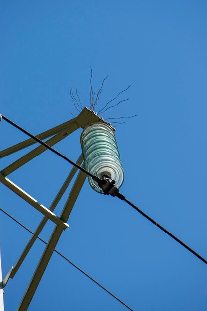 Low angle view of power lines against clear blue sky