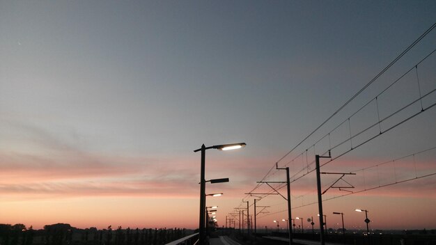 low angle view of power lines at sunset