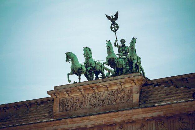 Photo low angle view of quadriga statue on brandenburg gate against sky in city