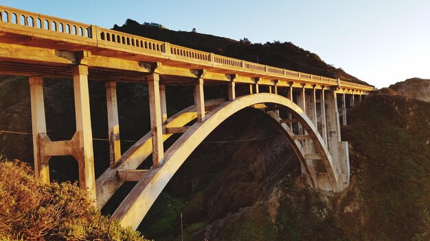 Foto vista a basso angolo del ponte ferroviario contro un cielo limpido