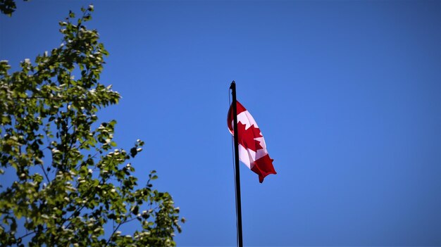 Photo low angle view of red flag against blue sky