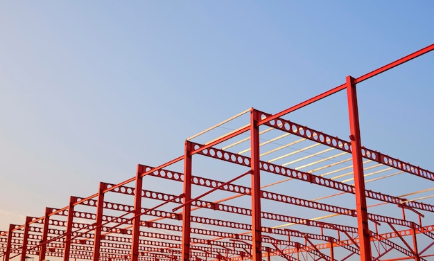 Low angle view of Red metal castellated beam structure of industrial building in construction site