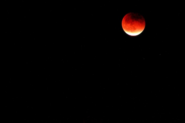 Low angle view of red moon at night