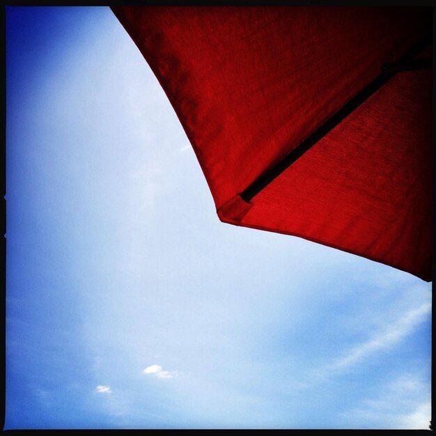 Low angle view of red wall against blue sky