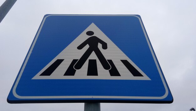 Low angle view of road sign against blue sky