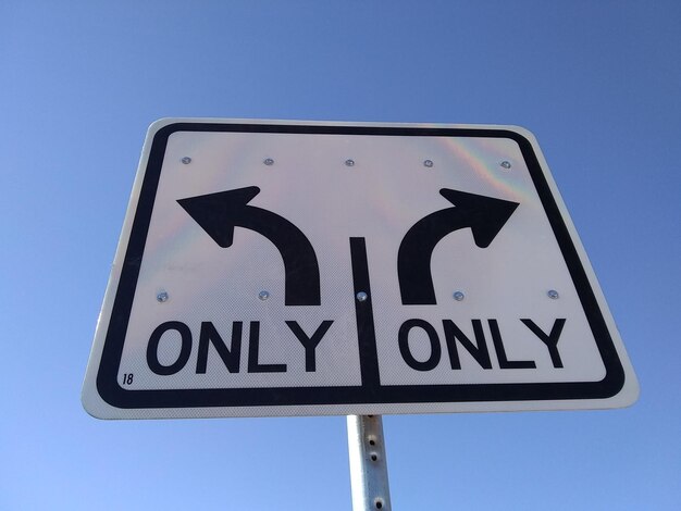 Photo low angle view of road sign against clear blue sky