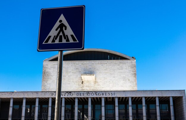 Low angle view of road sign against clear blue sky