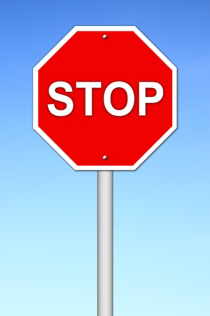 Low angle view of road sign against clear blue sky