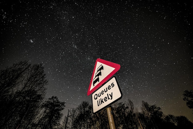 Photo low angle view of road sign against sky at night