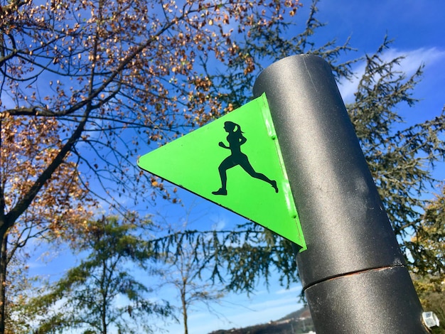 Photo low angle view of road sign against trees