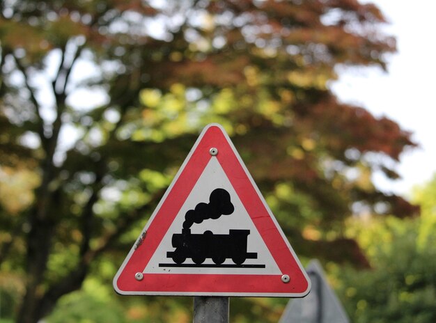 Photo low angle view of road sign against trees