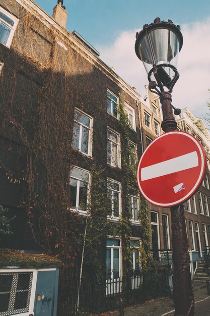 Low angle view of road sign by building against sky