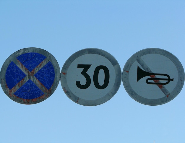 Photo low angle view of road signs against clear blue sky