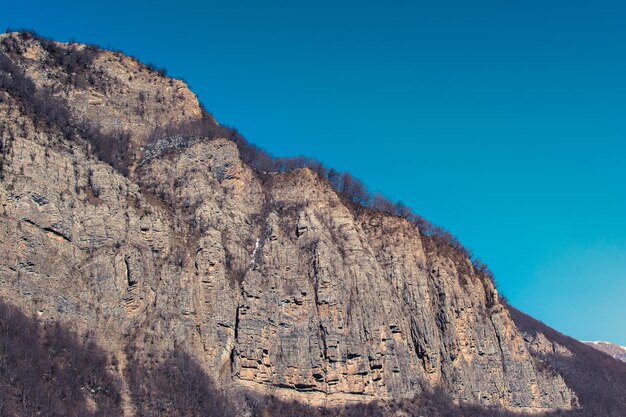 Low angle view of rock formation against clear blue sky