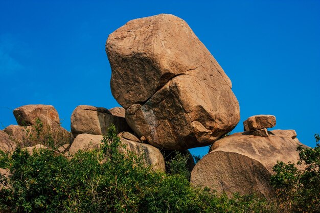 Low angle view of rock formation against clear blue sky