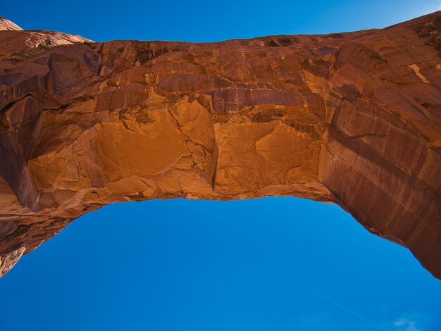 Low angle view of rock formation against clear blue sky