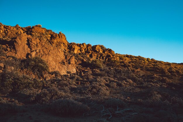 Low angle view of rock formation against clear blue sky