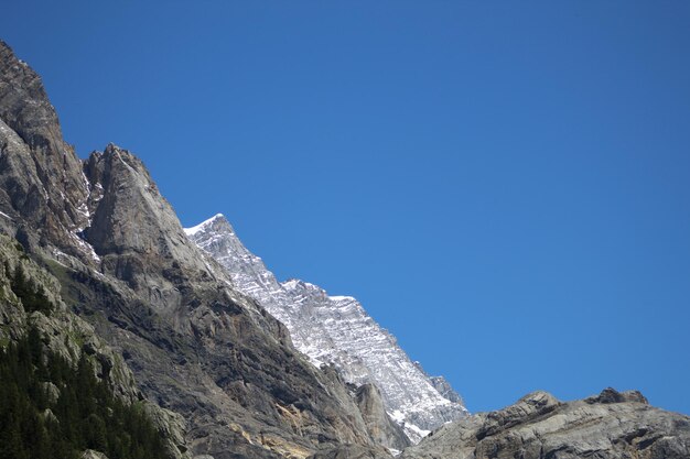 Low angle view of rock formation against clear blue sky