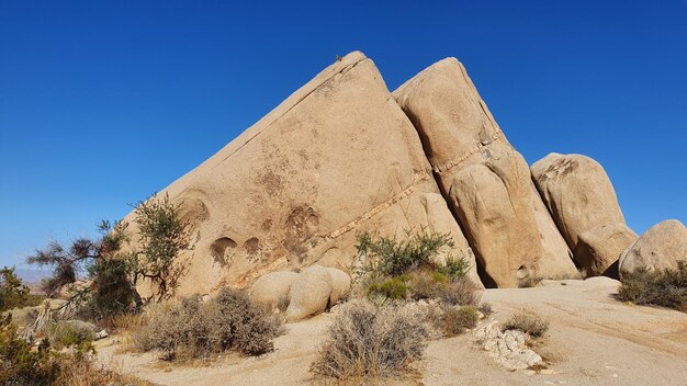 Low angle view of rock formations against clear blue sky