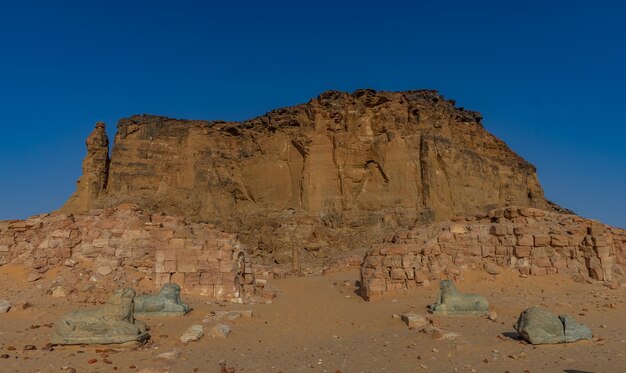 Low angle view of rock formations against clear blue sky