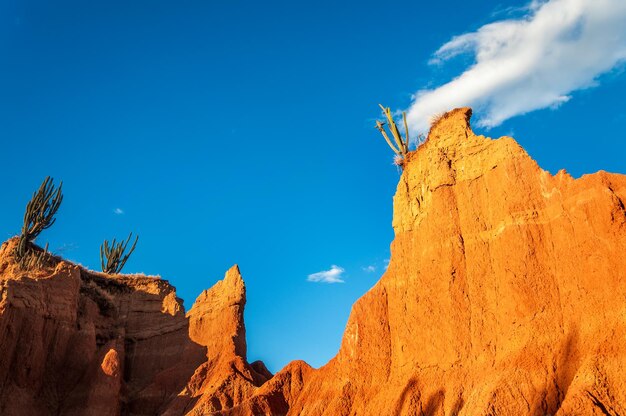 Low angle view of rock formations at tatacoa desert against blue sky