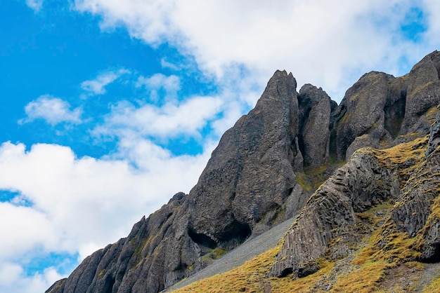 Low angle view of rock formations on volcanic landscape against blue sky