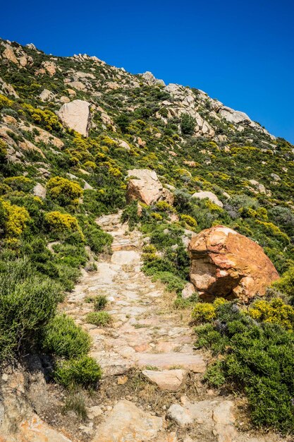 Low angle view of rocky mountain against blue sky